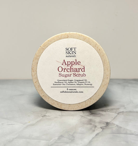 Apple Orchard Sugar Scrub container with 'Soft Skin Naturals' branding on a marble surface.