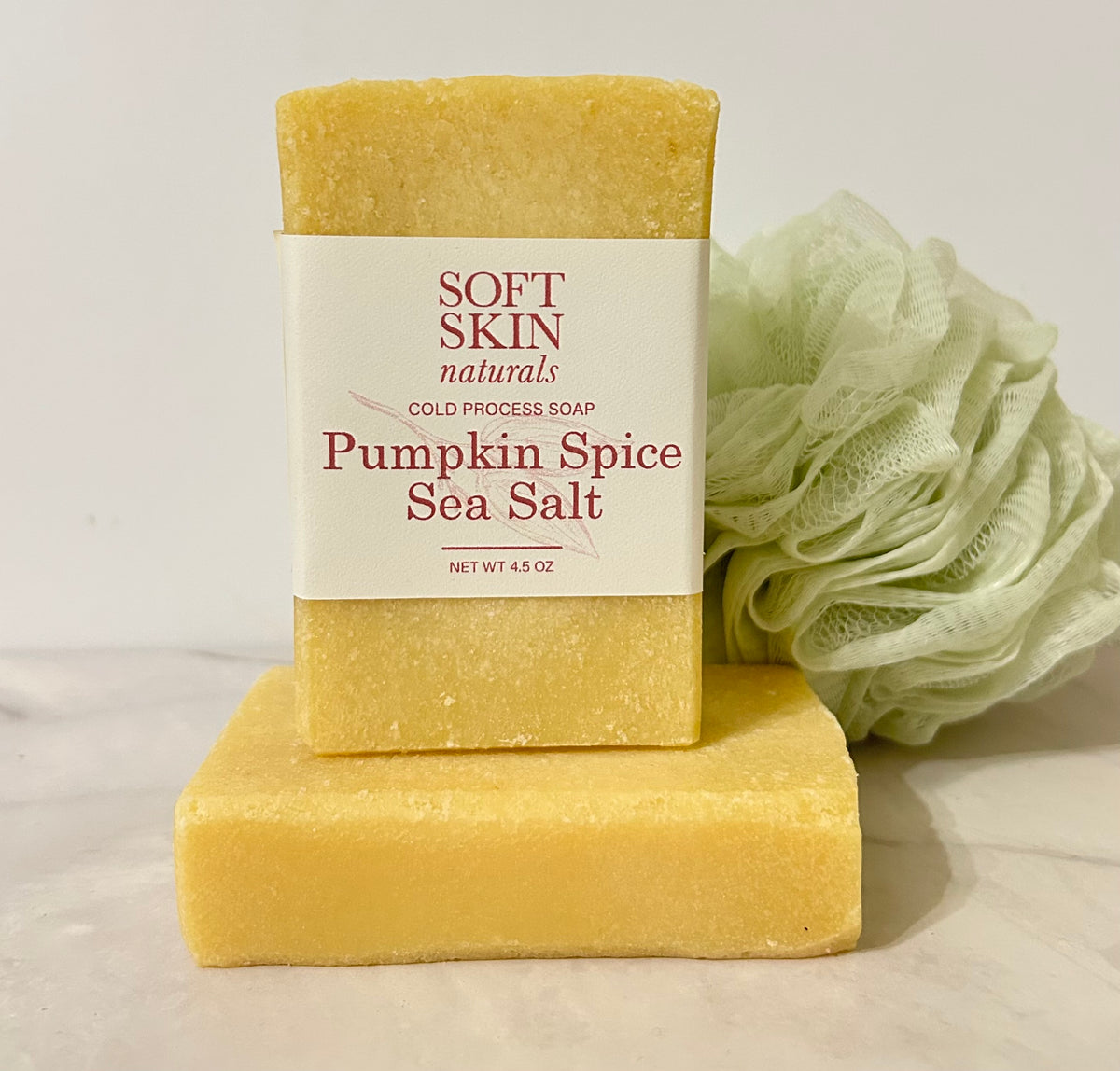 Two bars of Pumpkin Spice Sea Salt with a shower pouf