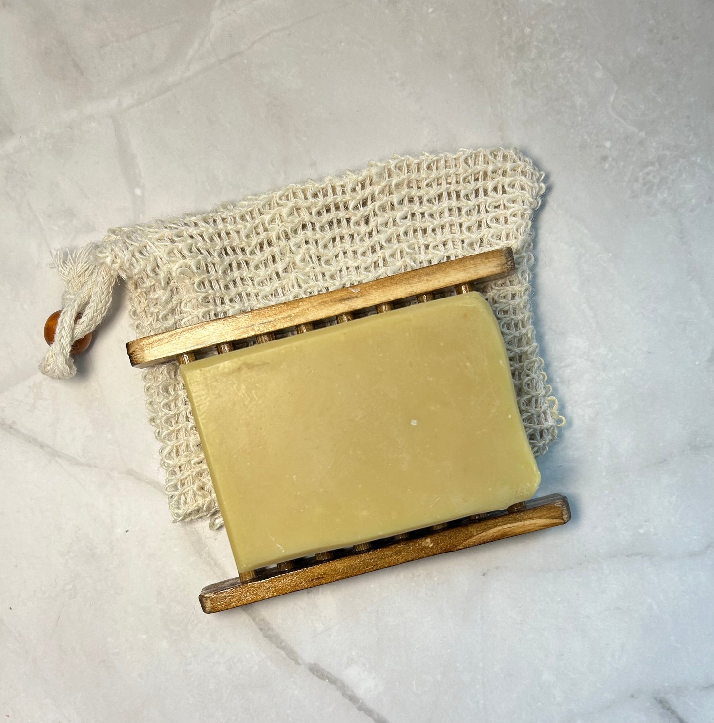 Soap on a wooden soap holder and mesh ag