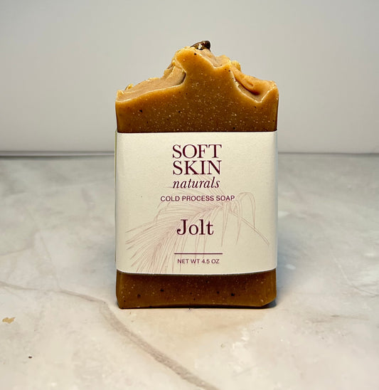 This coffee soap is sitting on a marbled surface.