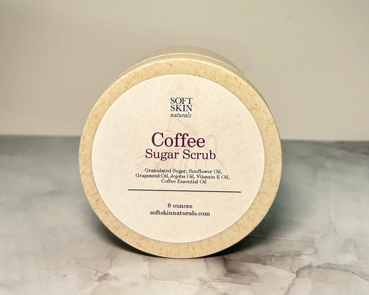 Jar of coffee sugar scrub with 'Soft Skin' branding on a marble surface.