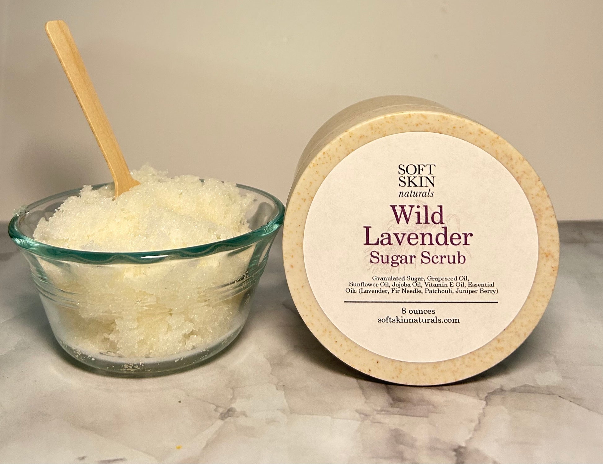 Wild Lavender Sugar Scrub with a wooden spoon on a marble surface