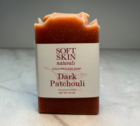 A bar of Dark Patchouli handmade soap with a label that reads 'Soft Skin Naturals - Cold Process Soap