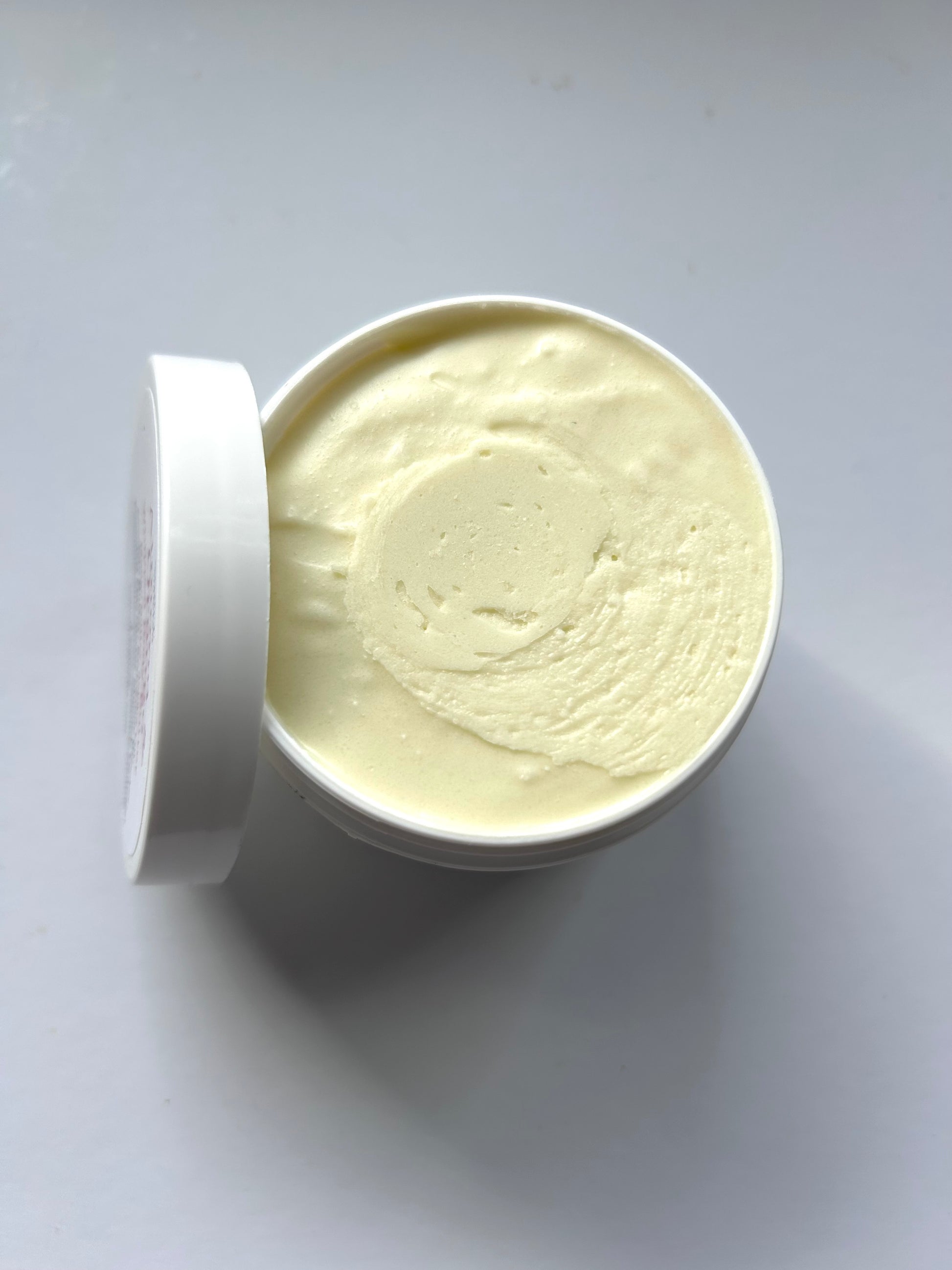 Open container of cream on a white background