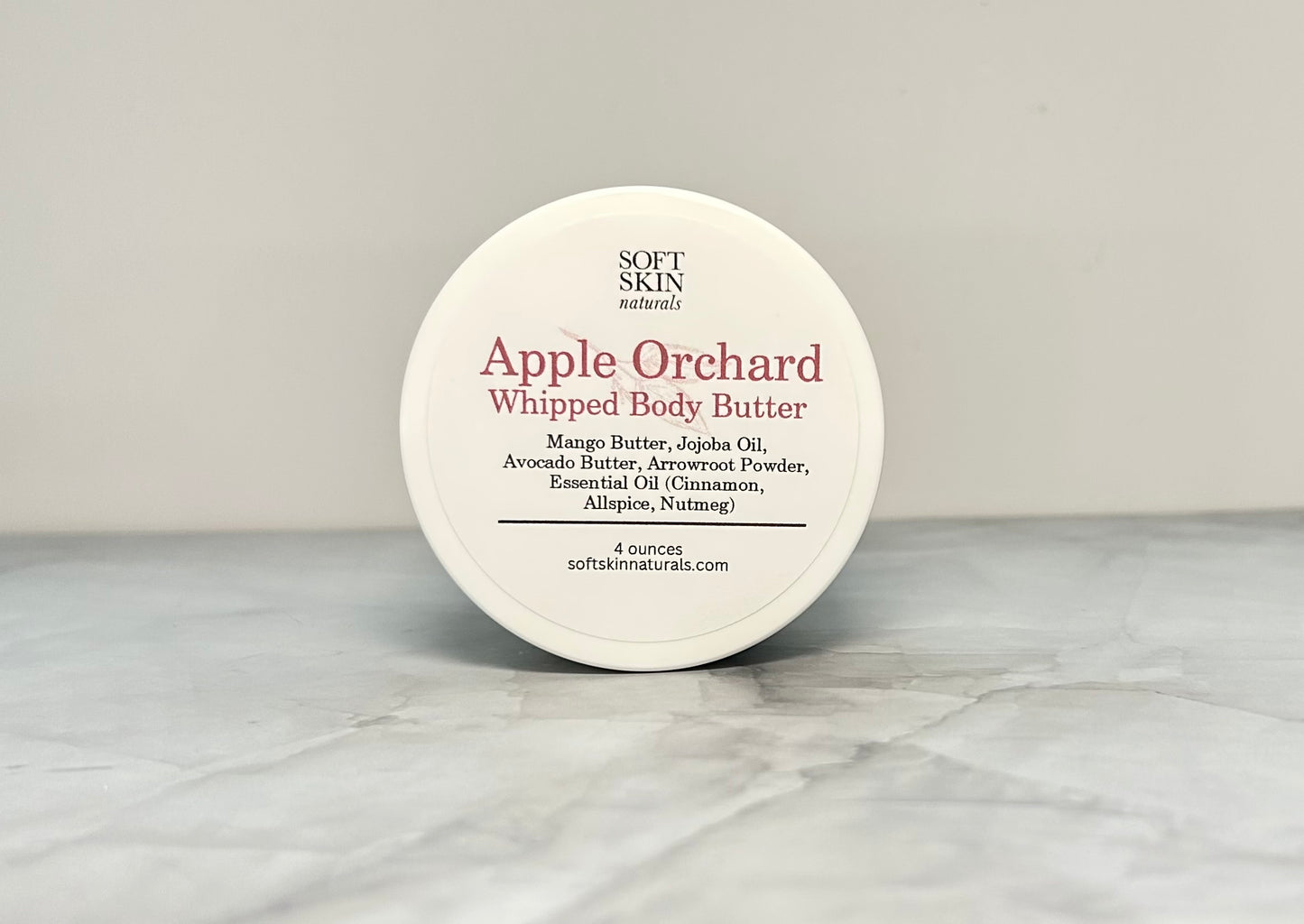 Jar of Apple Orchard whipped body butter sitting on a marbled table. 
