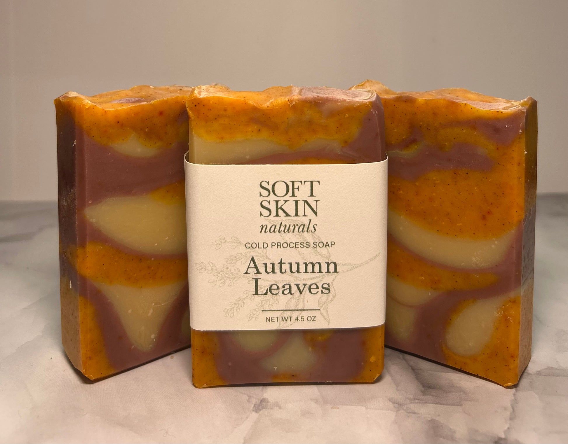 Three bars of 'Autumn Leaves' soap with a label on a marble surface