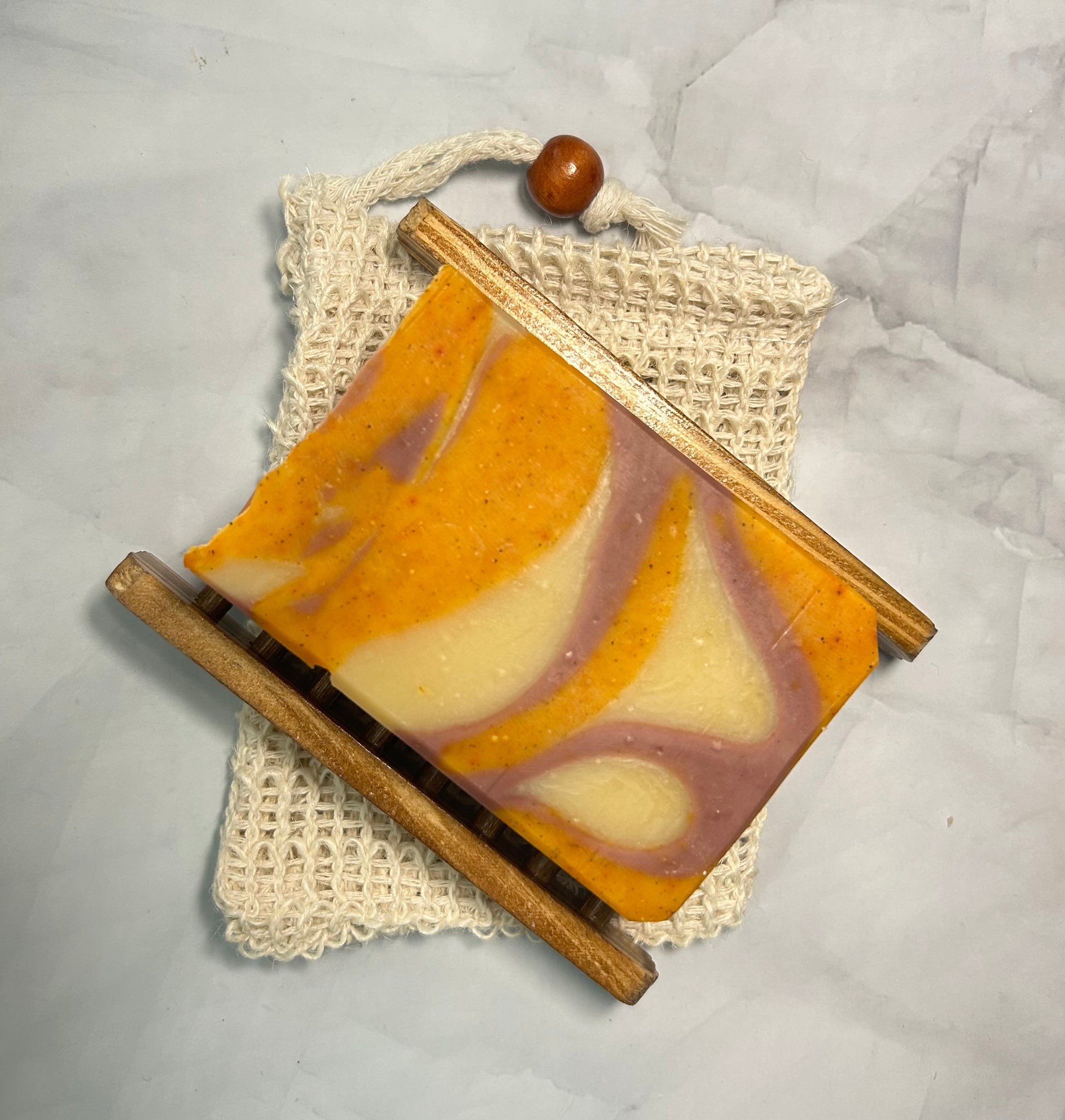 Handmade soap with a wooden holder on a textured surface