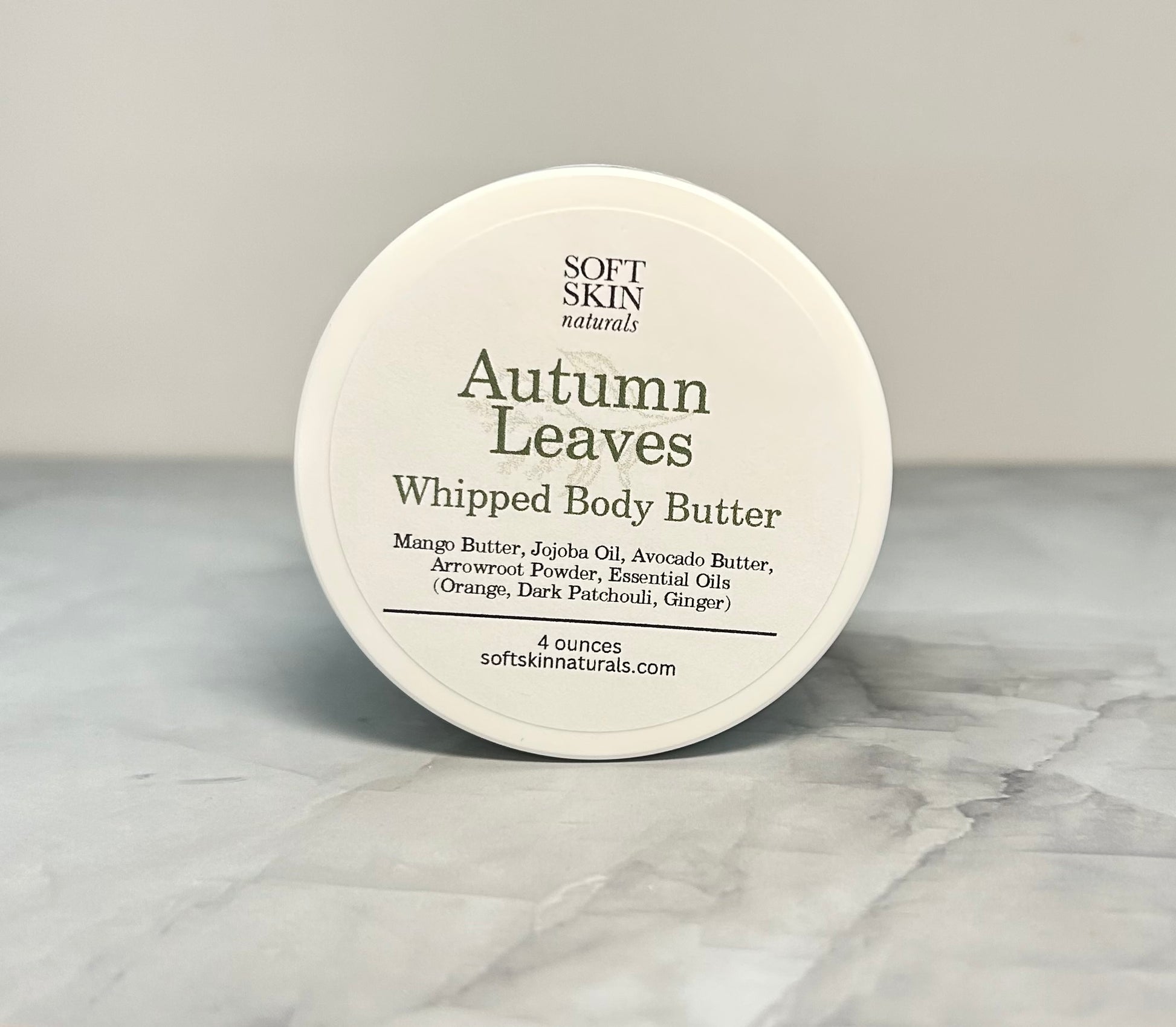 Jar of Autumn Leaves whipped body butter sitting on a table. 