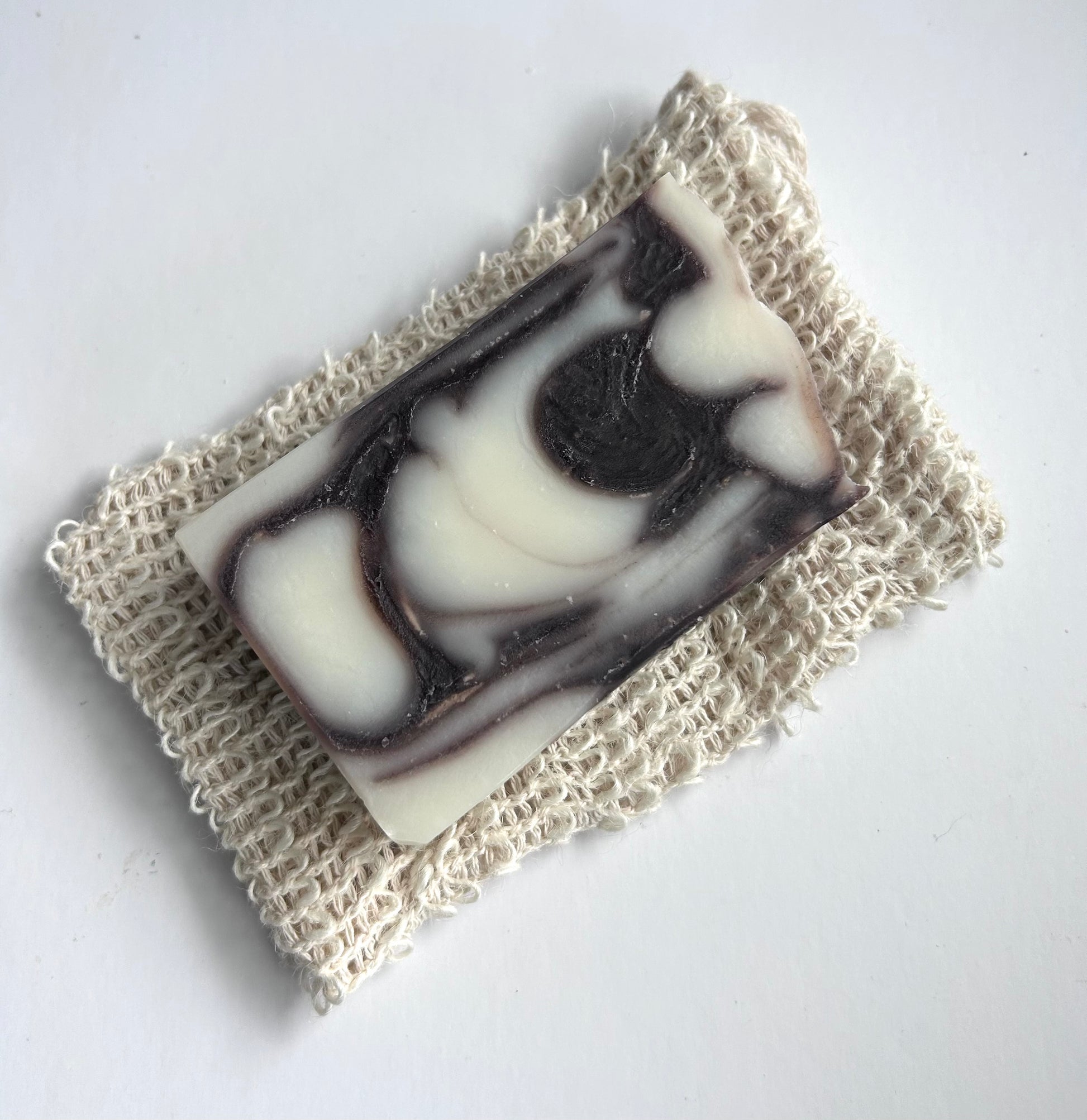 Bar of soap with black and white swirls on a textured white surface