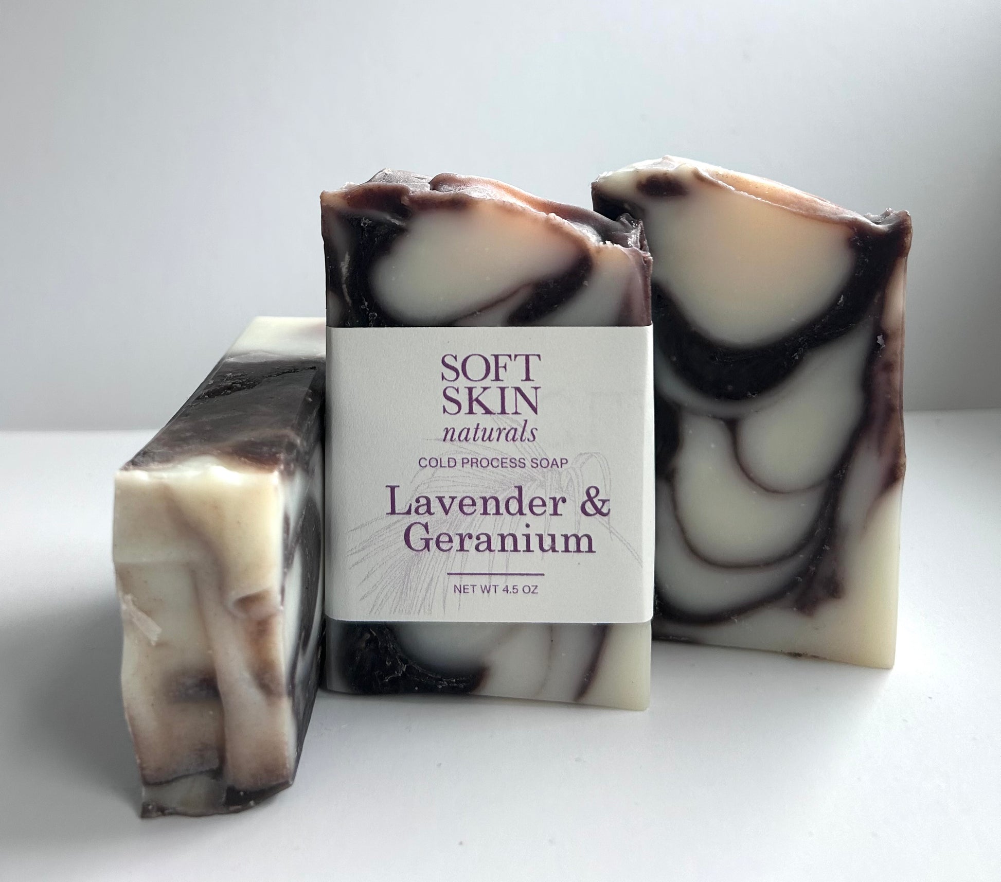 Three bars of soap with a 'Soft Skin Naturals' label on a white background