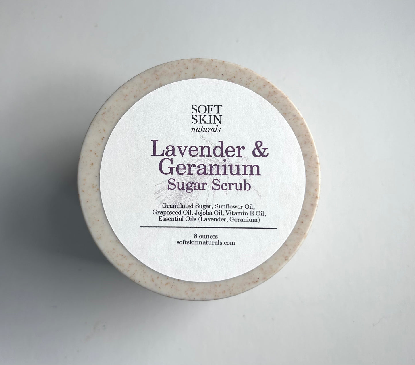 Lavender & Geranium sugar scrub container with a white label on a gray background