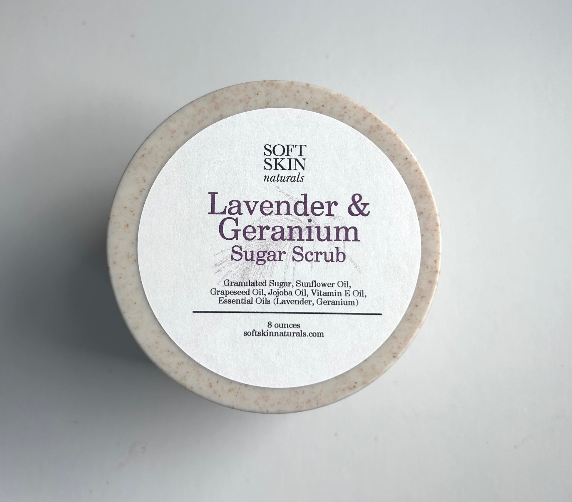Lavender & Geranium sugar scrub container with a white label on a gray background