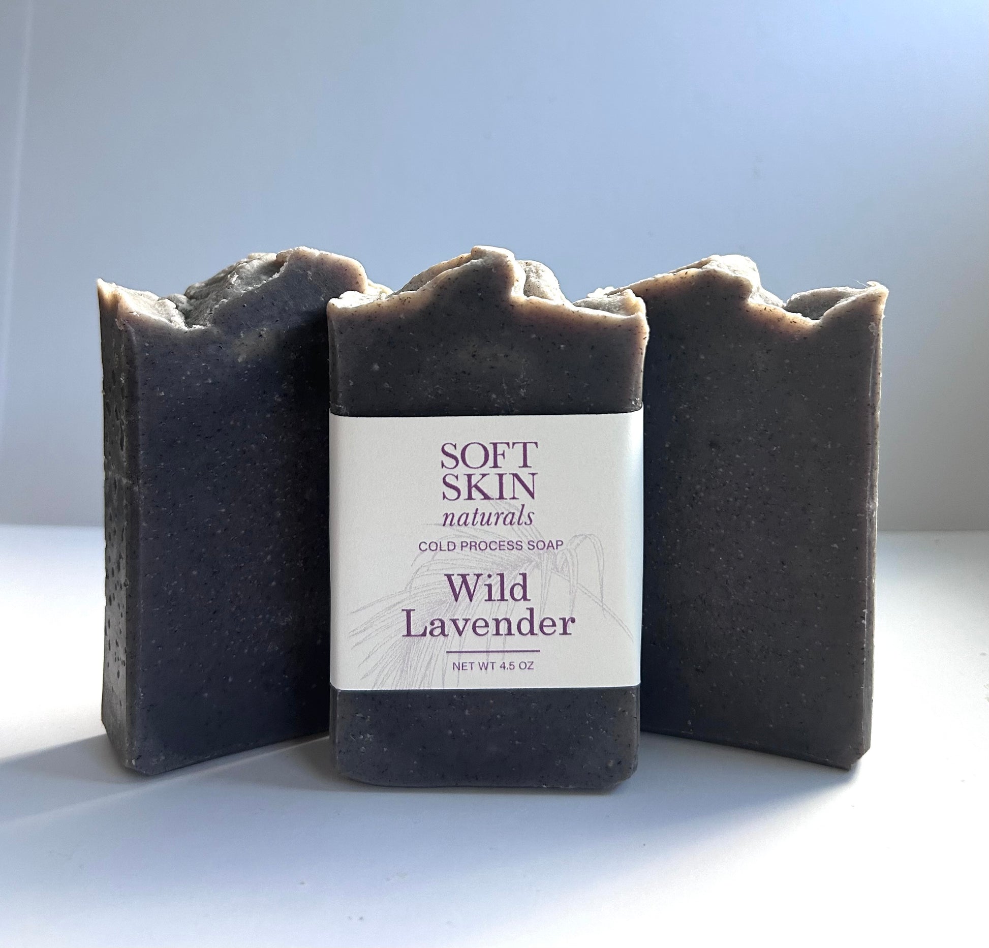 Three bars of Wild Lavender soap from Soft Skin Naturals on a light background