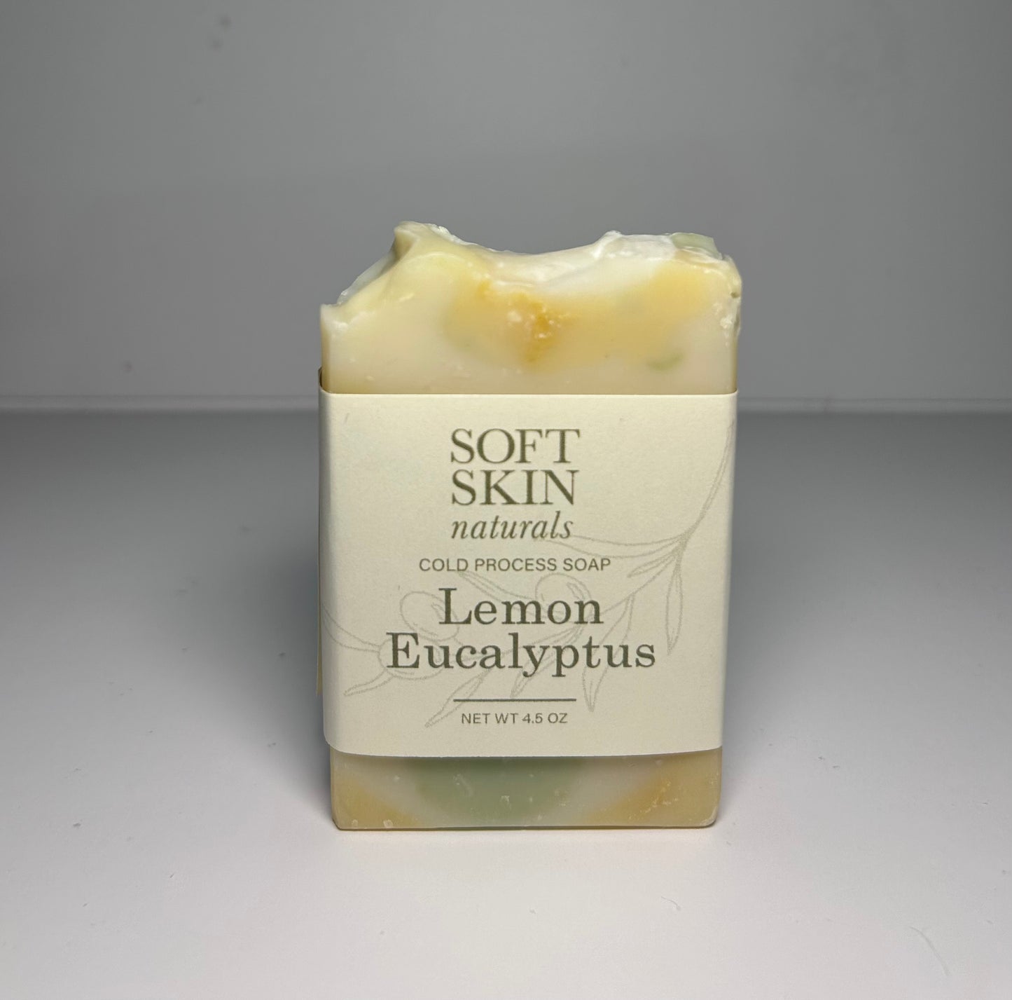 Bar of soap labeled Soft Skin Naturals Lemon Eucalyptus on a gray background