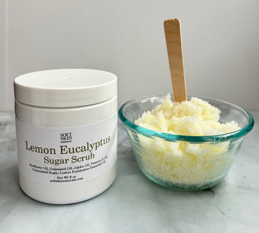 Jar of Lemon Eucalyptus Sugar Scrub with a bowl of scrub ingredients on a light surface.