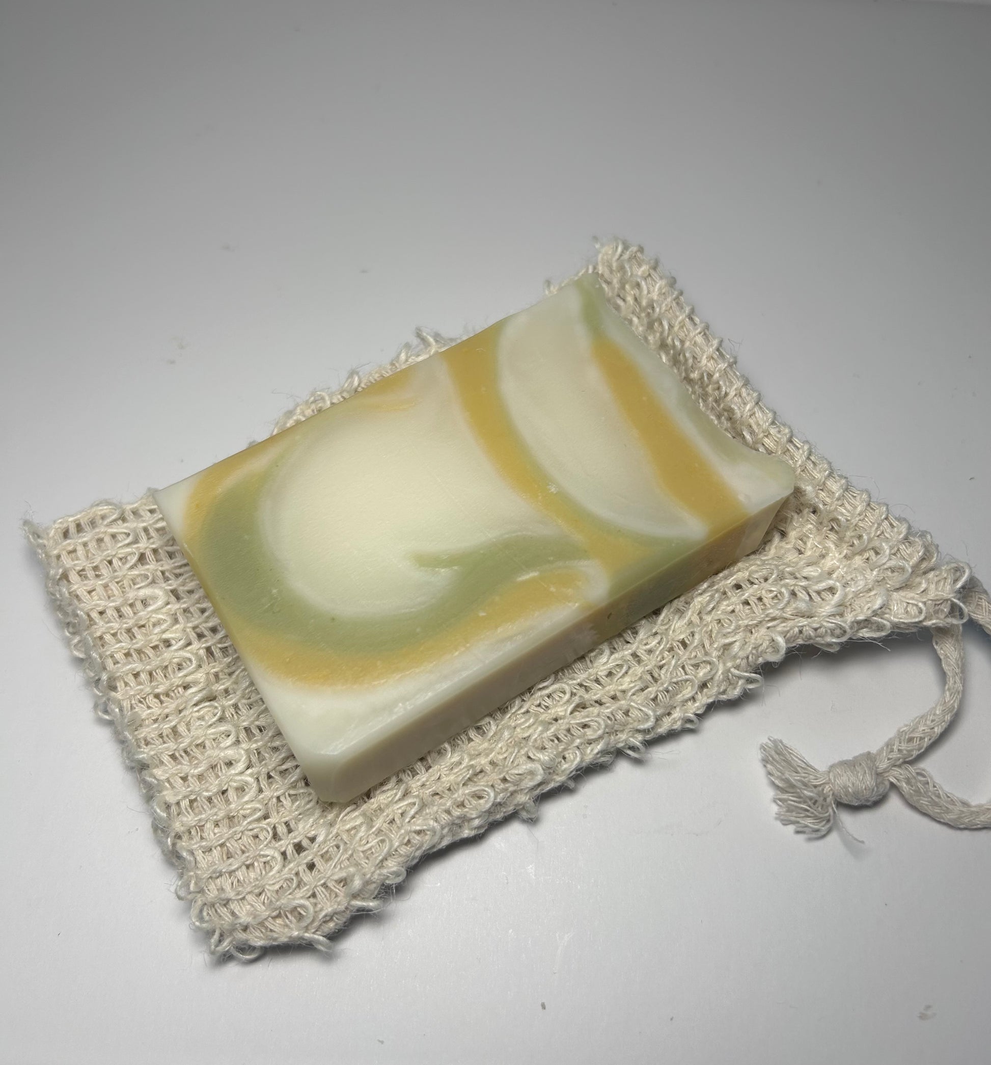 Bar of soap on a textured white surface with a white background