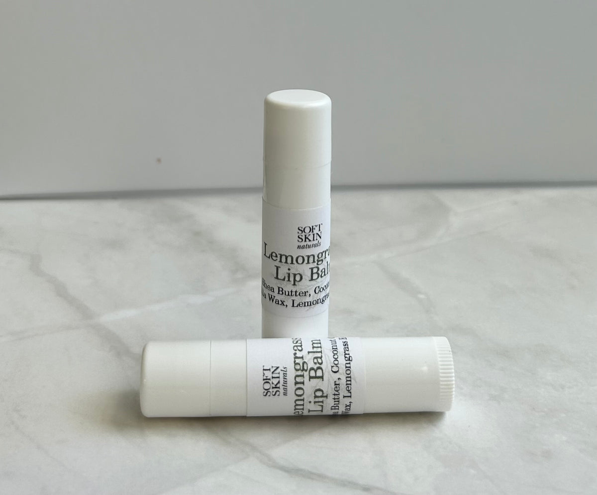 Two lip balms on a marble surface with a neutral background