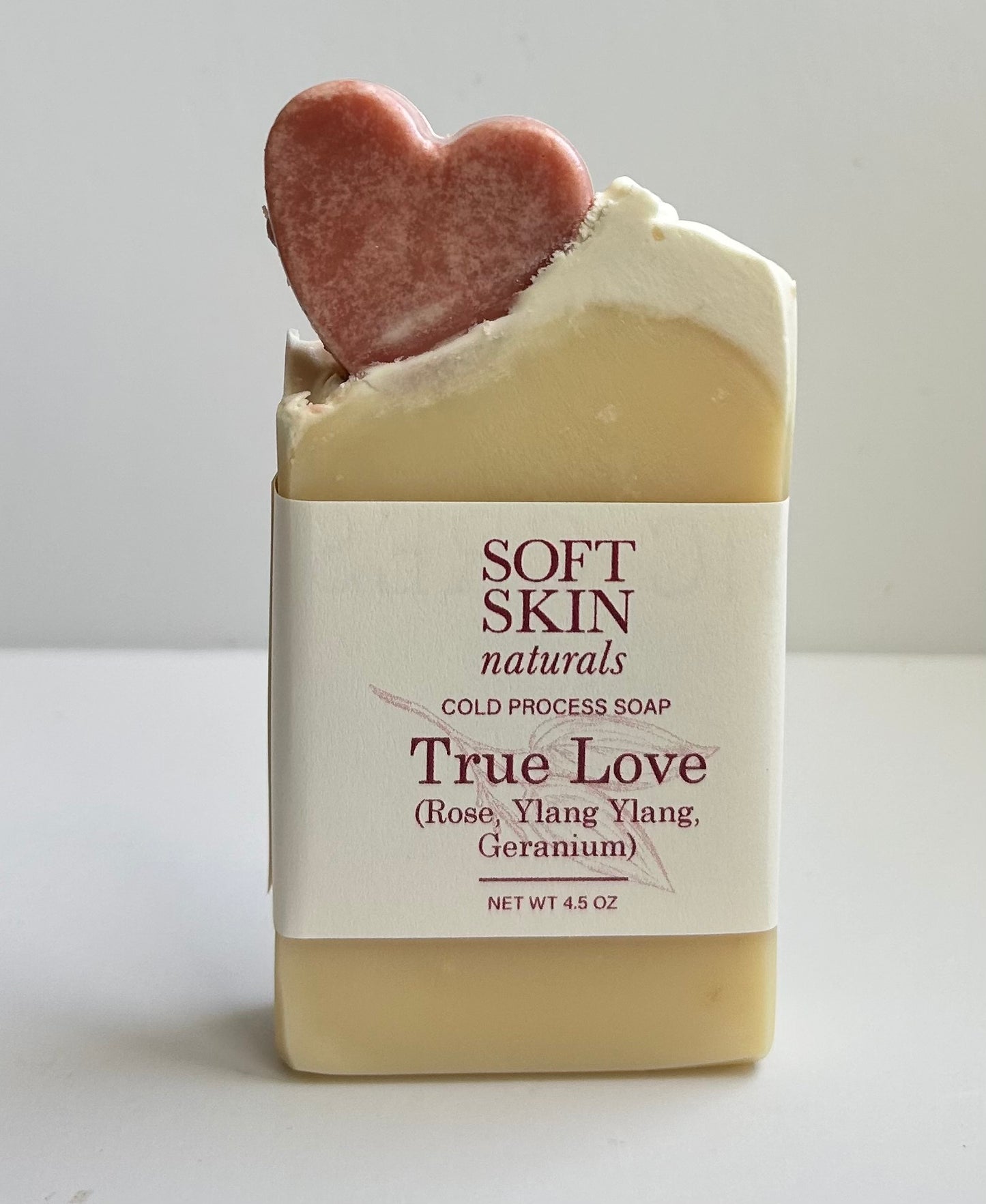 Bar of soap with a heart-shaped object on top, labeled on a white background.