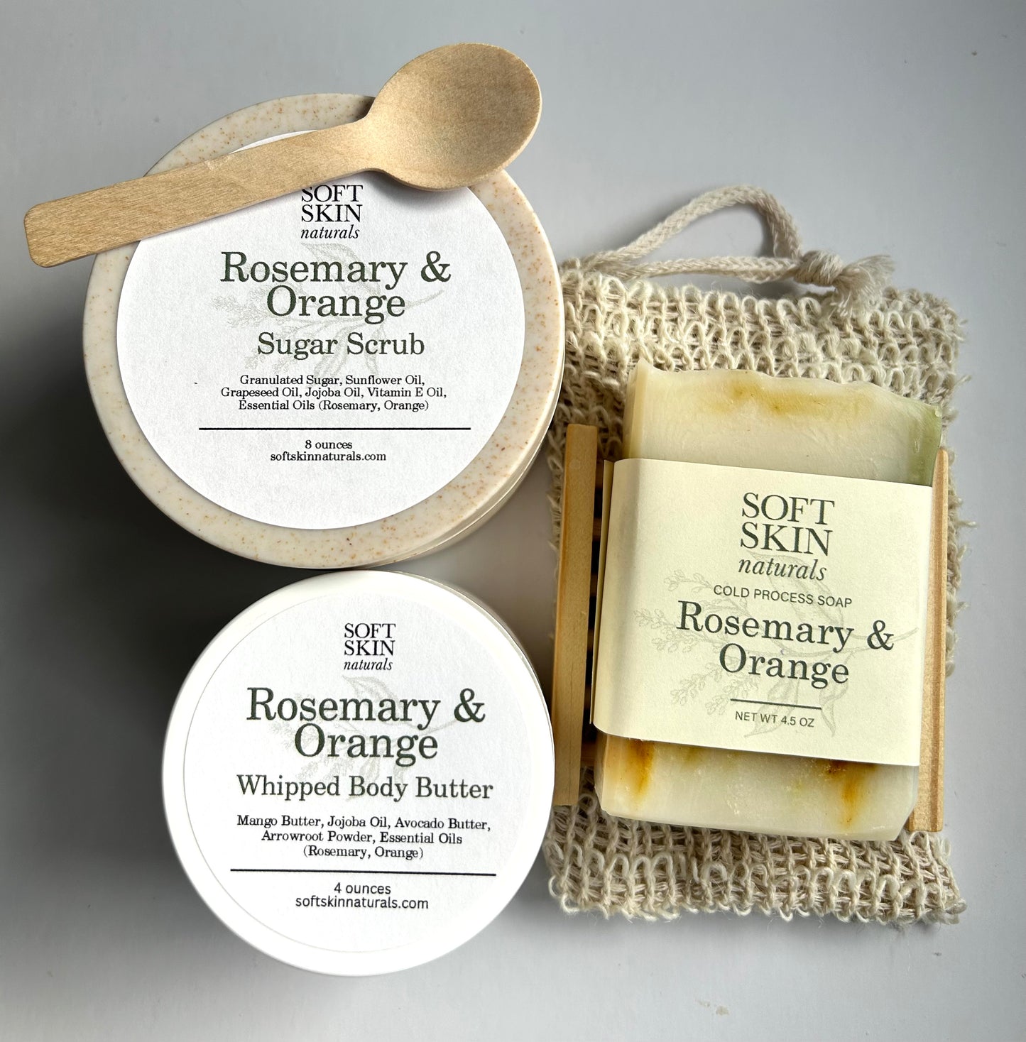 Trio of rosemary and orange soap, body butter, and scrub in containers.