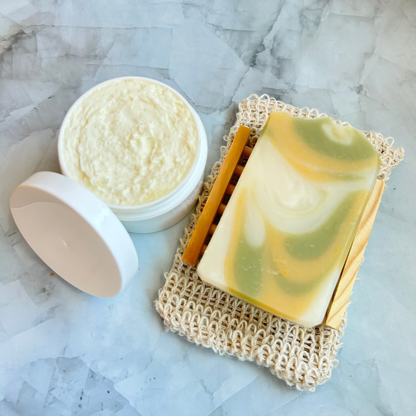 Bar of soap and a jar of cream on a marble surface